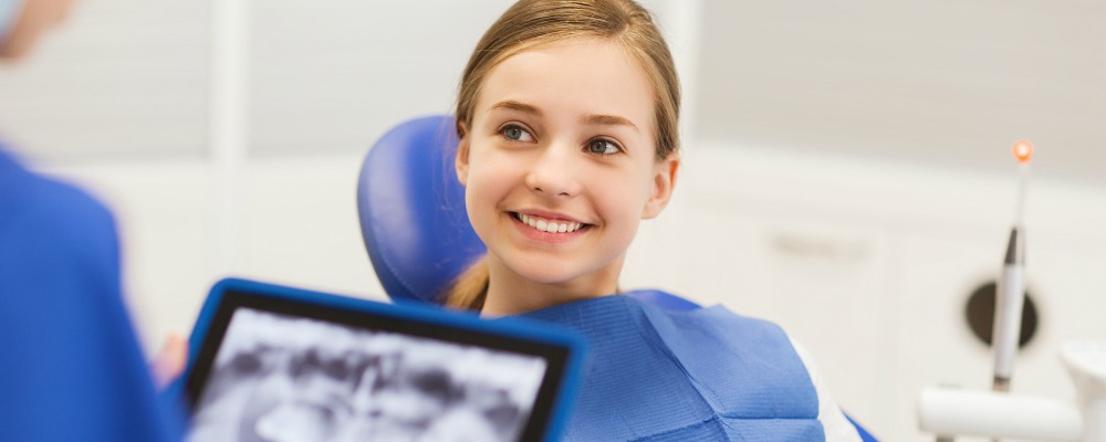 young girl smiling while receiving facial imaging